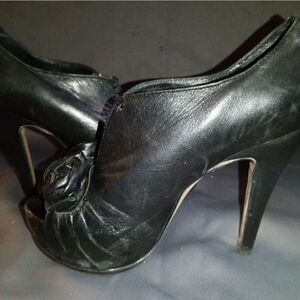 Vince Camuto black leather open toed heels w 3 roses across the front, 5.5